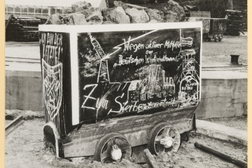 Abbildung einer Schachtanlage auf der Seitenwand eines Förderwagens. 