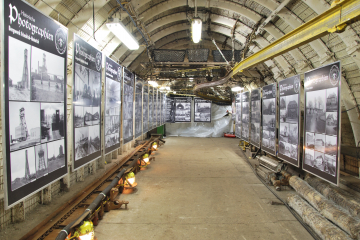 Blick in den Lehrstollen des Museums mit einer Fotoausstellung an den Seitenwaenden